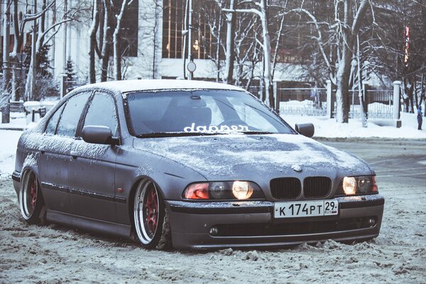A snow-covered BMW on a winter road