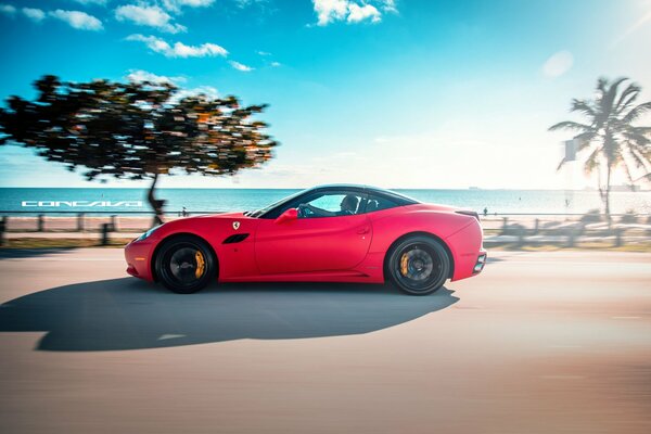 Red matte ferrari on the background of the road and sky