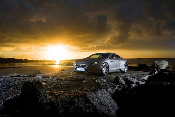 Voiture grise sur fond de soleil couchant