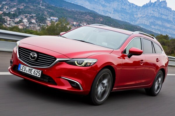 Mazda rossa su un bellissimo sfondo di montagne