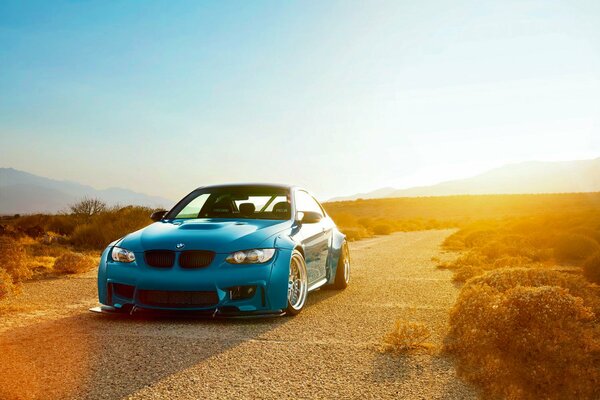 Blue car at sunset in the steppe