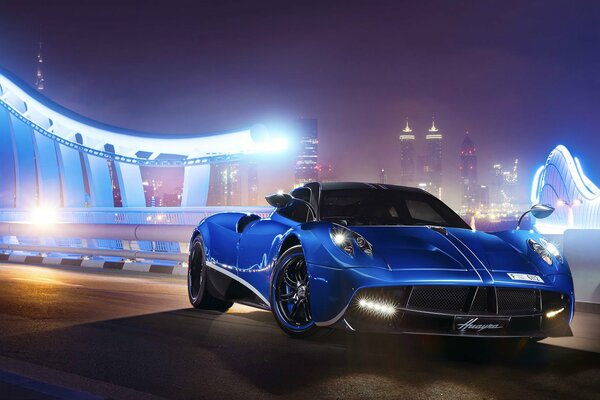 Supercar bleu Pagani Huayra sur fond de ville de nuit