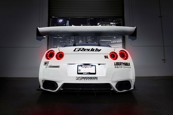 White Nissan with spoiler. Rear view