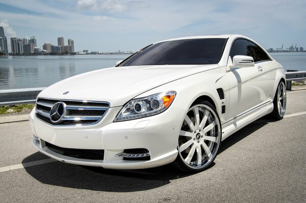 White Mercedes cl63 amg, v8 along the water coast