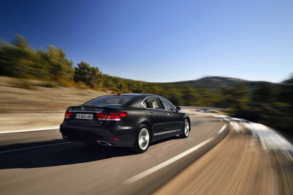 Coche negro Lexus en movimiento