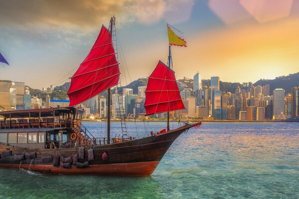 A ship with scarlet sails on the background of the city