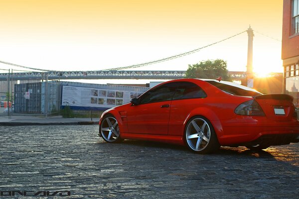 Schöner Sonnenuntergang in der Stadt. roter Mercedes