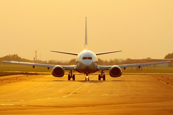 Boeing est sur la piste au coucher du soleil