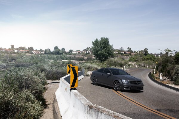 El coche negro mate se encuentra semidesnudo en la carretera vallada