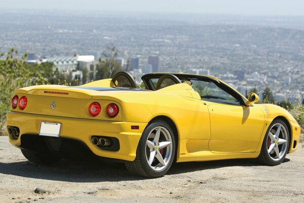 Yellow Ferrari car on the background of the city