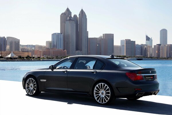 Black BMW car on the background of a city panorama