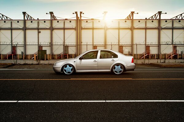 Volkswagen on the road against the background of an industrial building