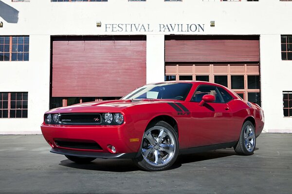 Red dodge challenger car at the building