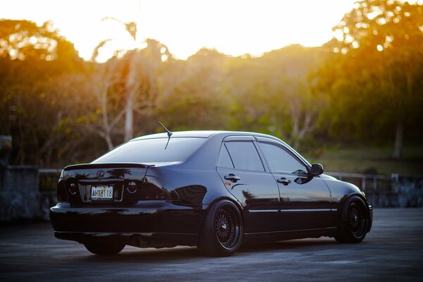 Black tuned Lexus at sunset