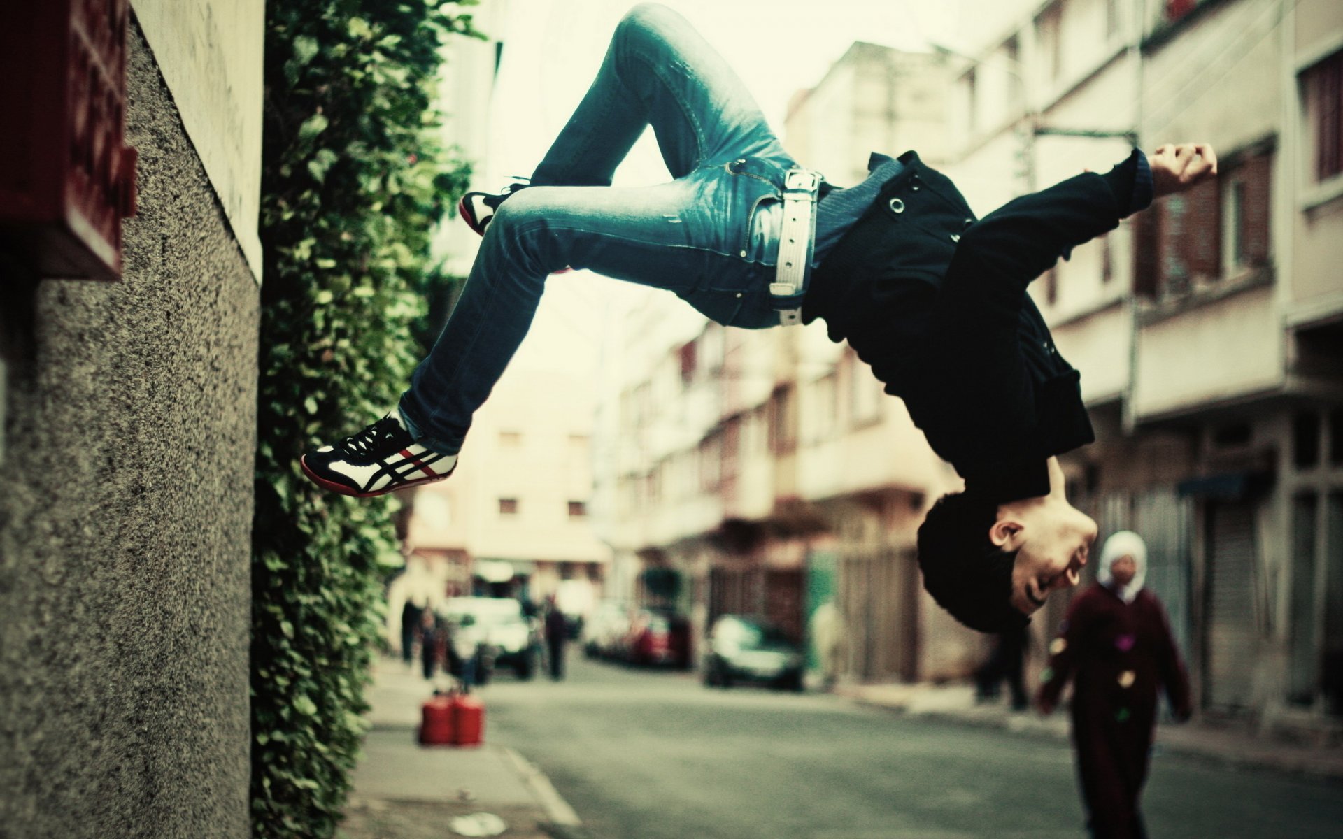 pared ciudad chico volteretas transeúntes jeans arbusto parkour