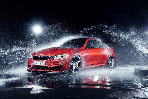 Czerwony soczysty BMW z rozpryskami wody