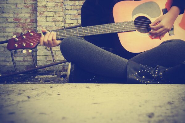 Girl sitting playing guitar