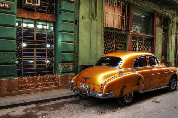 Ein orangefarbenes Retro-Auto in den Straßen von Havanna