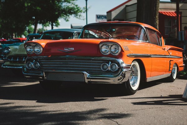 Cooles Retro-orange Auto steht auf der Straße