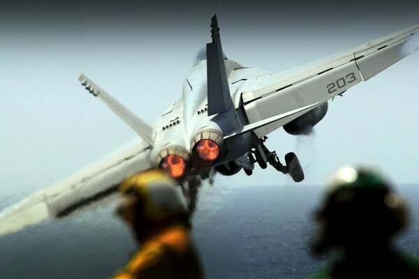 Take-off of a white aircraft carrier over the sea