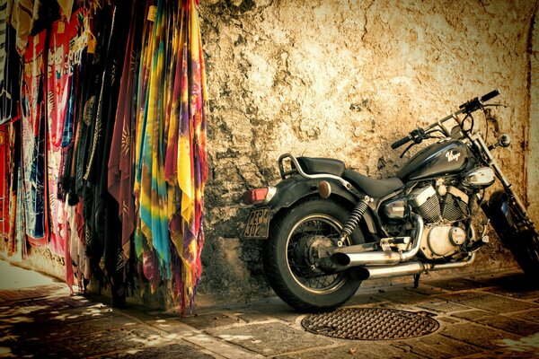 A black motorcycle stands on a brown background