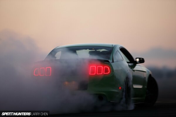 Ford Mustang ad alta velocità sullo sfondo del tramonto