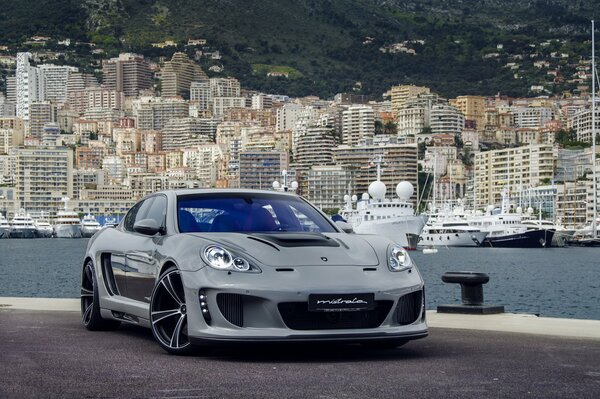 Porsche panamera en el muelle cerca de la gran ciudad