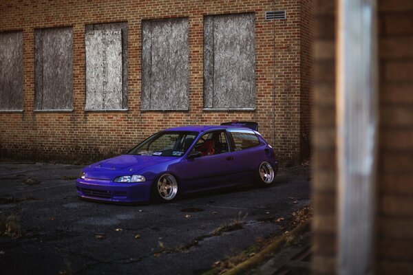 A HONDA car on the background of an abandoned building