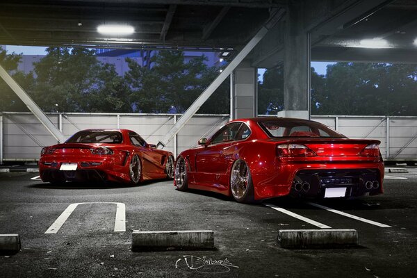 Dwa czerwone samochody Nissan s15 i mazda rx-7