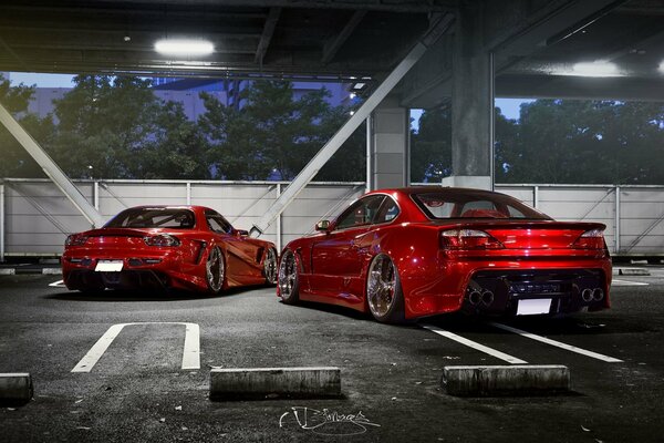 Два красных автомобиля Nissan s15 и mazda rx-7