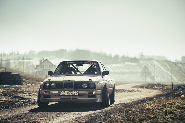 Silver BMW e30 car in the sun on the road