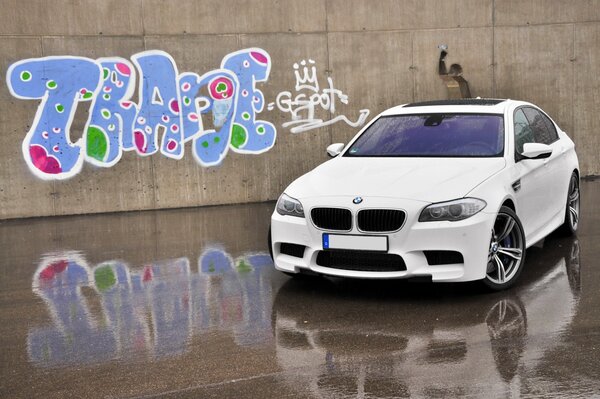 Bmw M5 auto bianca su sfondo graffiti