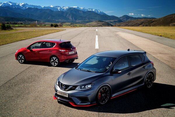 Dos coches de pie en la carretera en el fondo de las montañas