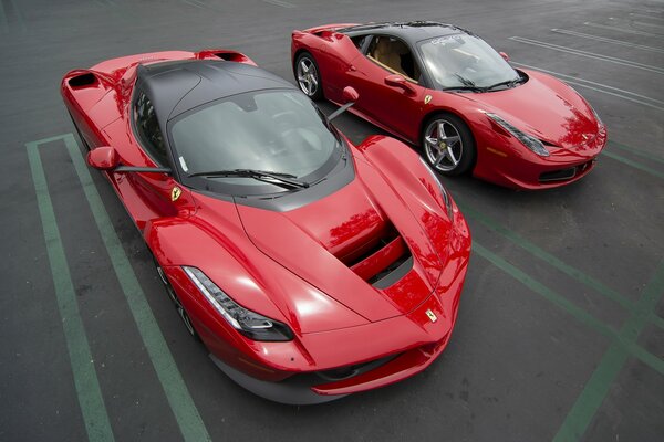 Two sporty red Ferraris in the parking lot