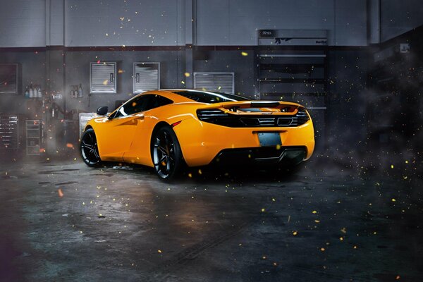 Mclaren arancione supercar in garage vista posteriore