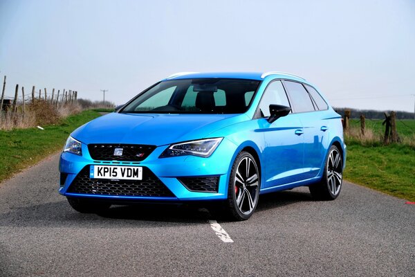 A blue car standing in the middle of the road