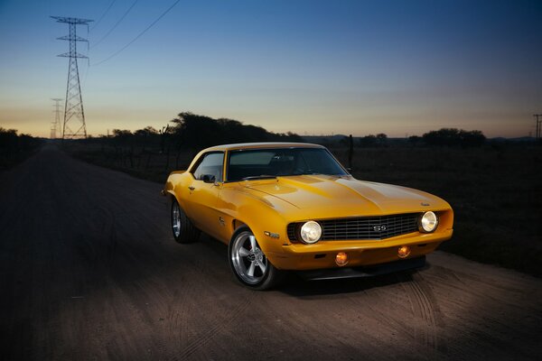 In the dark, a yellow chevrolet, camaro rides