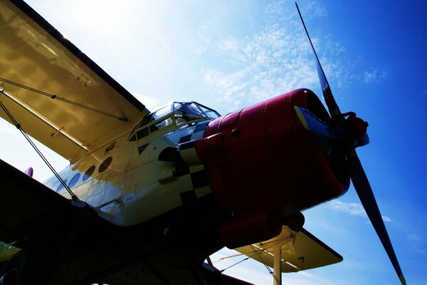 An airplane flies over the blue sky