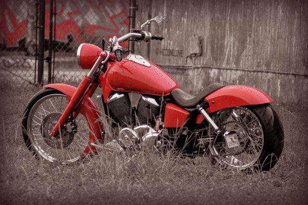 Design i styl. Czerwony rower, motocykl na tle ogrodzenia