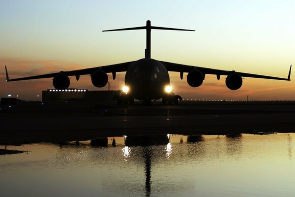 Las luces del avión se ven en la pista por la noche