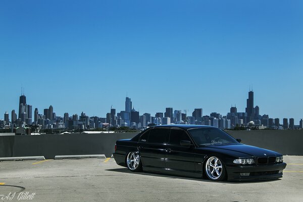 Tuned black BMW e38 on the background of Chicago in the USA