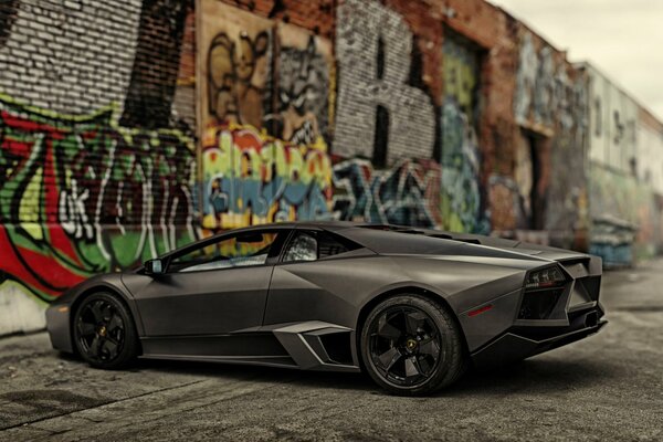 Lamborghini nero su sfondo muro con grafite