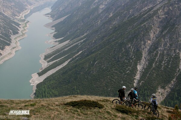 Велосипедисты на склоне красивая природа длинная река