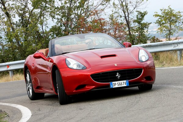 Frente a un Ferrari rojo en una curva de la carretera