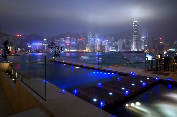 Night city of high-rise buildings with blue road lighting