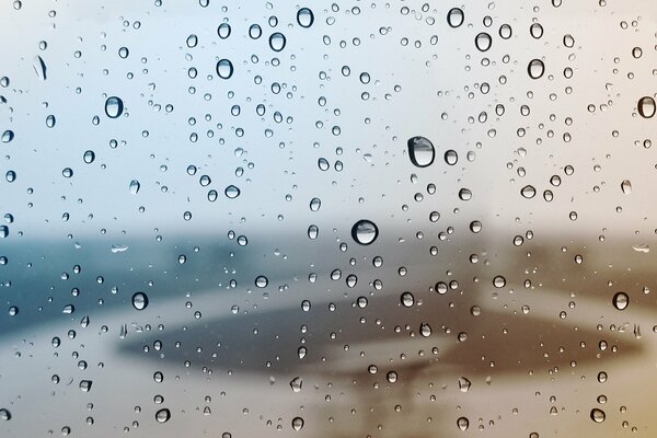 Schönes regnerisches Fenster mit Regentropfen