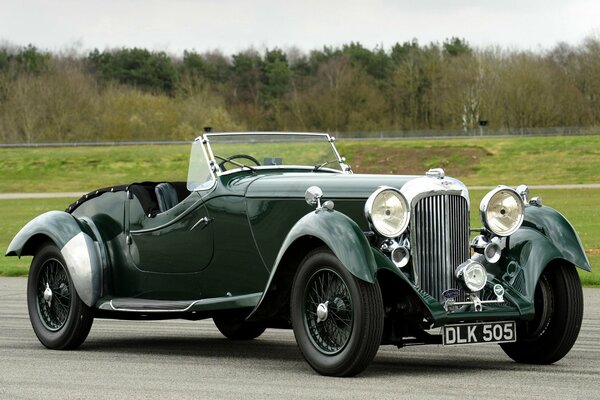 Green retro tourer rapide lagonda lg45 1937 on a grass background