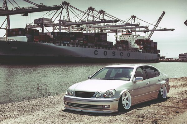 Lexus se encuentra en la orilla del río, y detrás de un gran barco