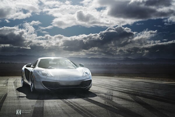 Silver mclaren supercar goes into the clouds