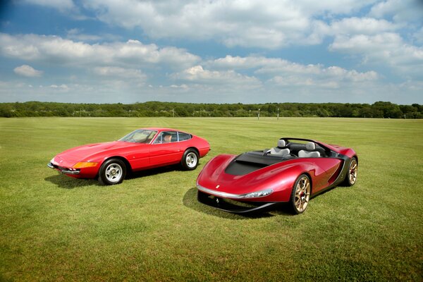 Two Ferraris from 1973 and 2013. In the field during the day